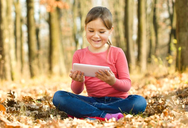 Маленька дівчинка читає з планшета — стокове фото
