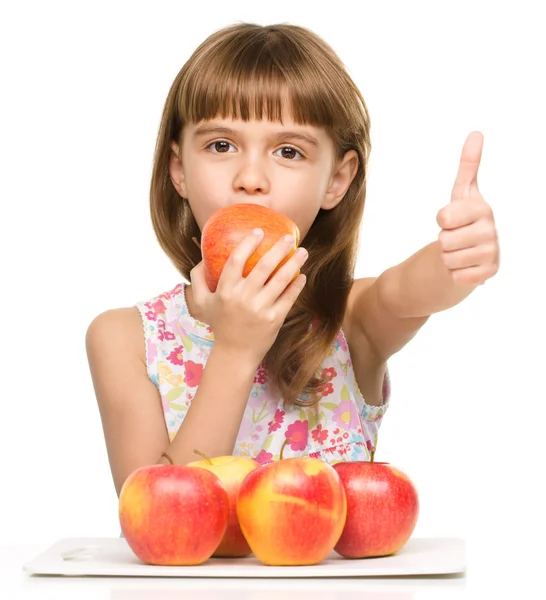Holčička s jablky se ukazuje palcem nahoru znamení — Stock fotografie