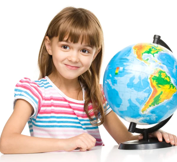 Klein meisje bestudeert globe — Stockfoto