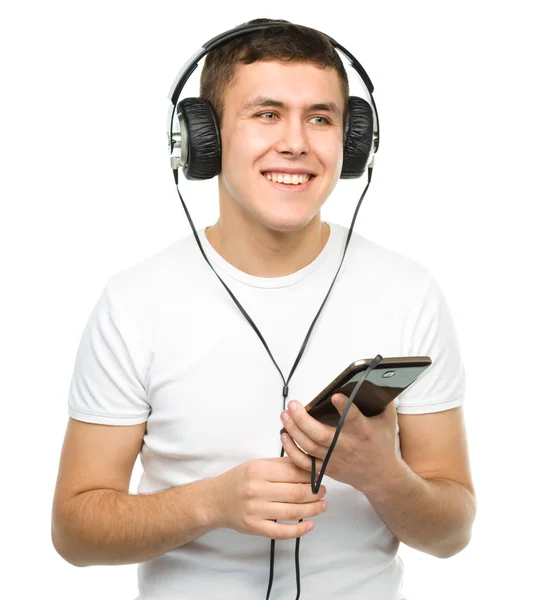 Young man enjoying music using headphones — Stock Photo, Image