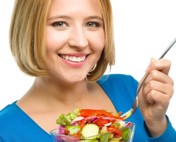 Jeune femme attirante mange salade à l'aide de la fourche若い魅力的な女性はフォークを使用してサラダを食べています。 — ストック写真