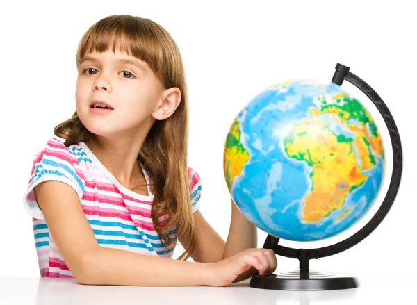 Маленькая девочка исследует глобус — стоковое фото