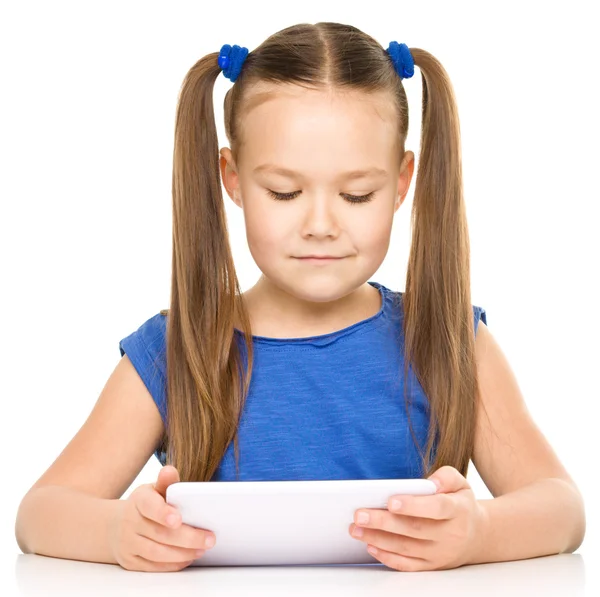 Giovane ragazza sta usando tablet Immagine Stock