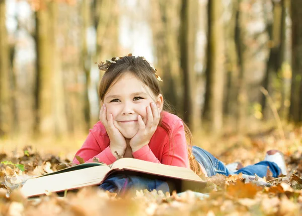 La niña está leyendo un libro al aire libre — Foto de Stock