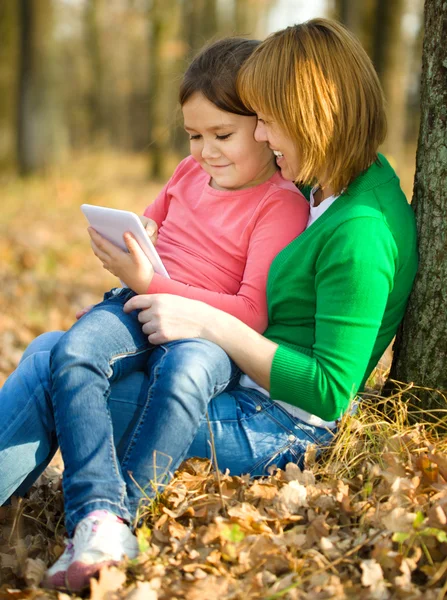 Madre y su hija están jugando con la tableta — Foto de Stock