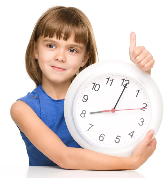 Маленькая девочка держит большие часы — стоковое фото
