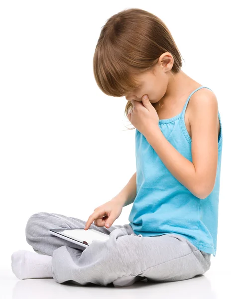 Chica joven está usando la tableta mientras está sentado en el suelo —  Fotos de Stock