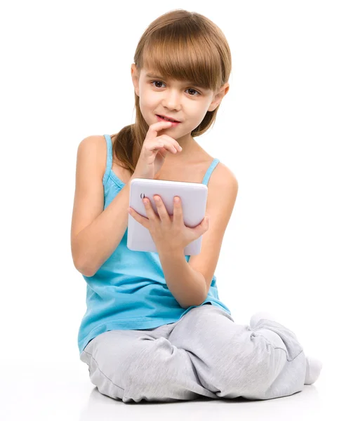 Chica joven está usando la tableta mientras está sentado en el suelo — Foto de Stock