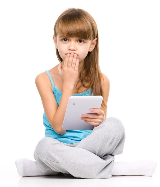 Young girl is using tablet while sitting on floor — Stock Photo, Image