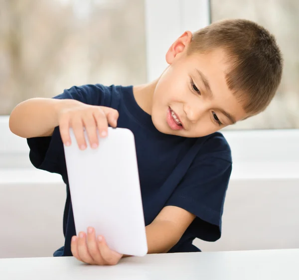 Niño joven está usando tableta —  Fotos de Stock