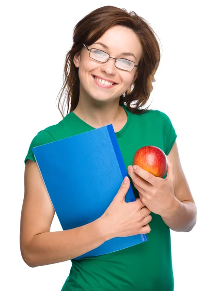 Joven estudiante chica está sosteniendo libro y manzana —  Fotos de Stock