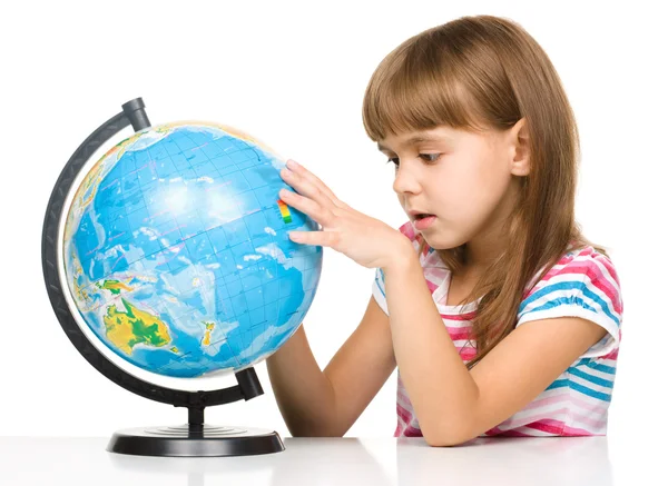 Little girl is examining globe — Stock Photo, Image