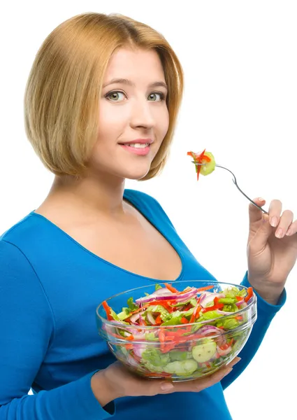 Giovane donna attraente sta mangiando insalata utilizzando forchetta — Foto Stock
