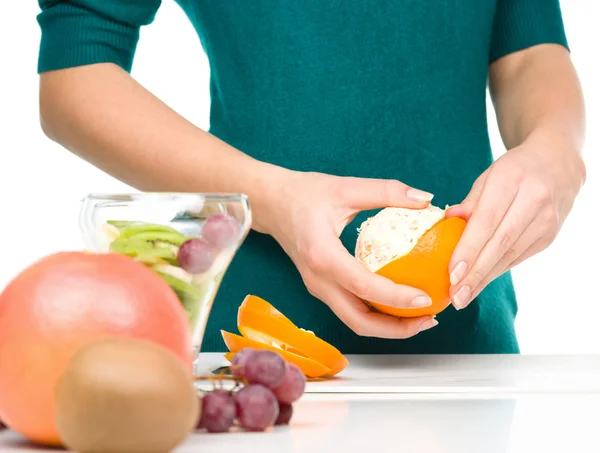 Cocinero está pelando naranja para postre de fruta — Foto de Stock