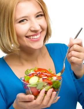 genç çekici kadın çatal kullanarak salata yiyor
