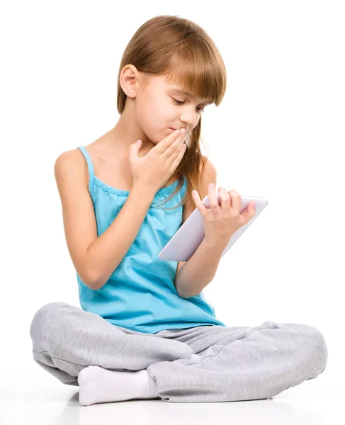 Young girl is using tablet while sitting on floor — Stock Photo, Image