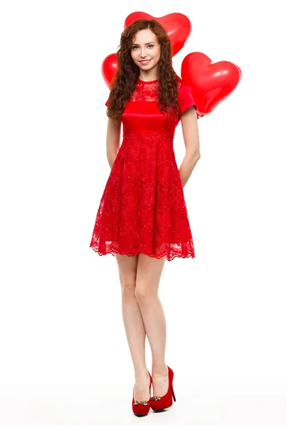 Mujer joven sosteniendo globos en forma de corazón — Foto de Stock