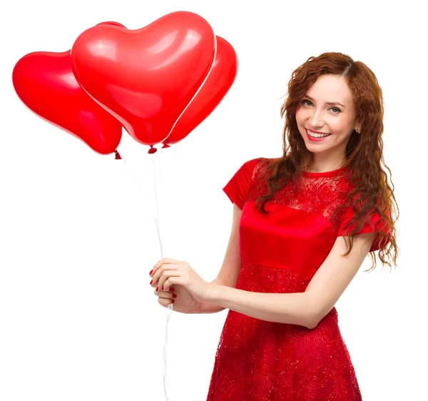 Young woman holding heart-shaped balloons — Stock Photo, Image