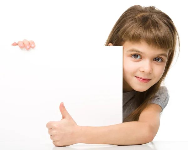 小さな女の子は空白のバナーから外を見てください。 — ストック写真