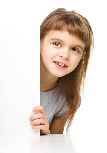 Маленькая девочка смотрит из пустого баннера — стоковое фото
