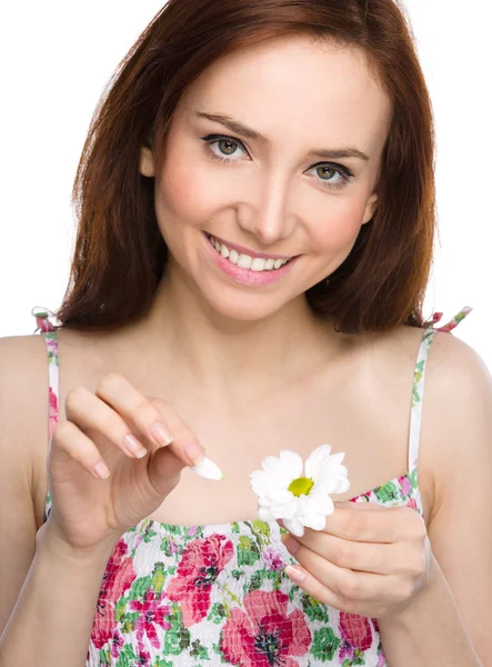 Jonge vrouw is scheuren van daisy bloemblaadjes — Stockfoto