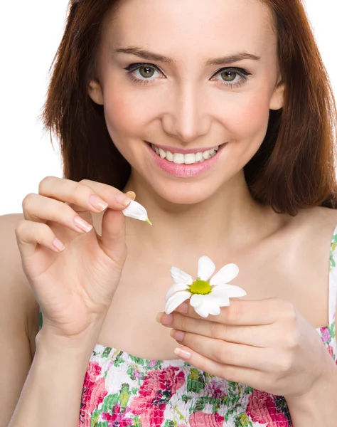 Young woman is tearing up daisy petals — Stock Photo, Image