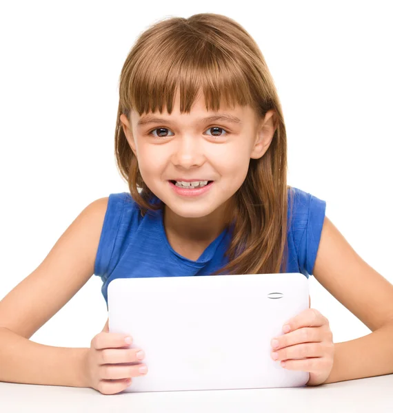 Jovem menina alegre está usando tablet — Fotografia de Stock