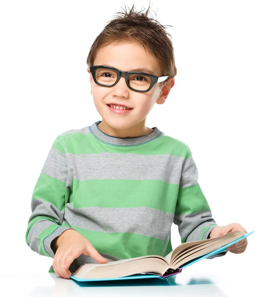 Liten pojke läser en bok — Stockfoto