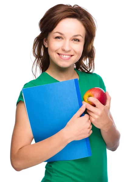 Joven estudiante chica está sosteniendo libro y manzana —  Fotos de Stock
