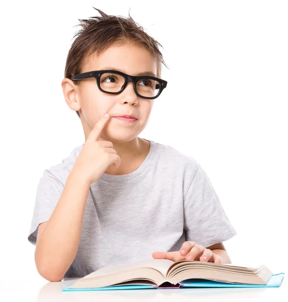 Молодий хлопчик мріє під час читання книги — стокове фото