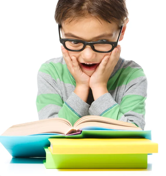 Zdumiony, mały chłopiec jest czytanie książek — Zdjęcie stockowe