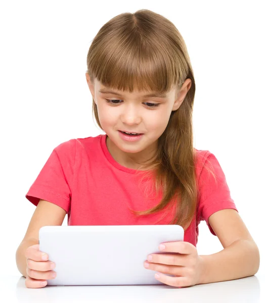 Jovem menina alegre está usando tablet — Fotografia de Stock