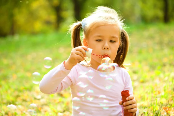 Little girl is blowing a soap bubbles — Stock Photo, Image