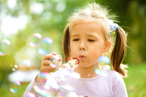 Little girl is blowing a soap bubbles — Stock Photo, Image