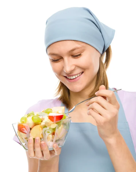 Jovem mulher atraente está comendo salada usando garfo — Fotografia de Stock