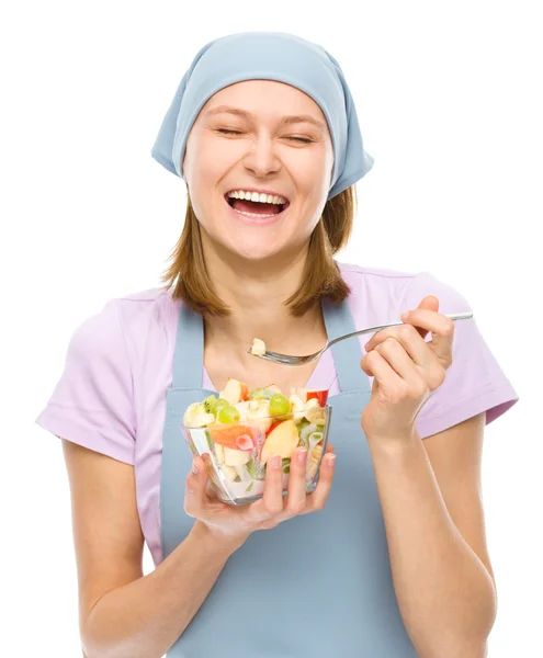 Молода приваблива жінка їсть салат, використовуючи виделку — стокове фото