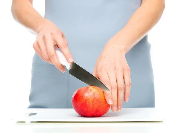 Cook is chopping red apple — Stock Photo, Image
