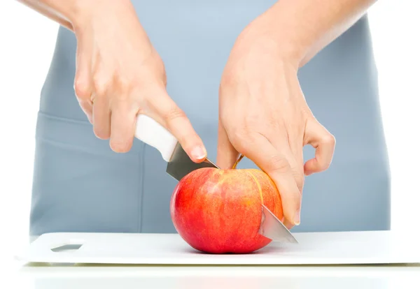 Cook is chopping red apple — Stock Photo, Image