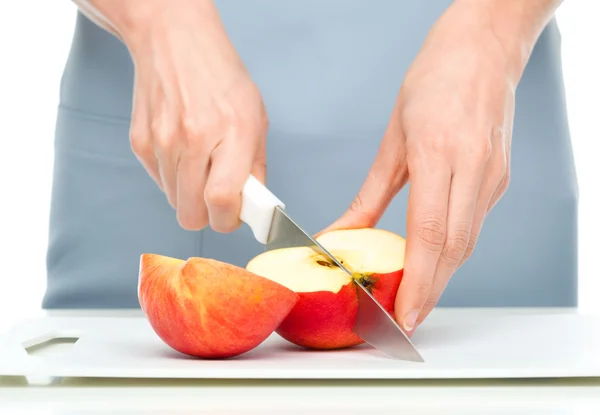 Cook is chopping red apple — Stock Photo, Image