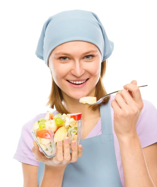 Jovem mulher atraente está comendo salada usando garfo — Fotografia de Stock