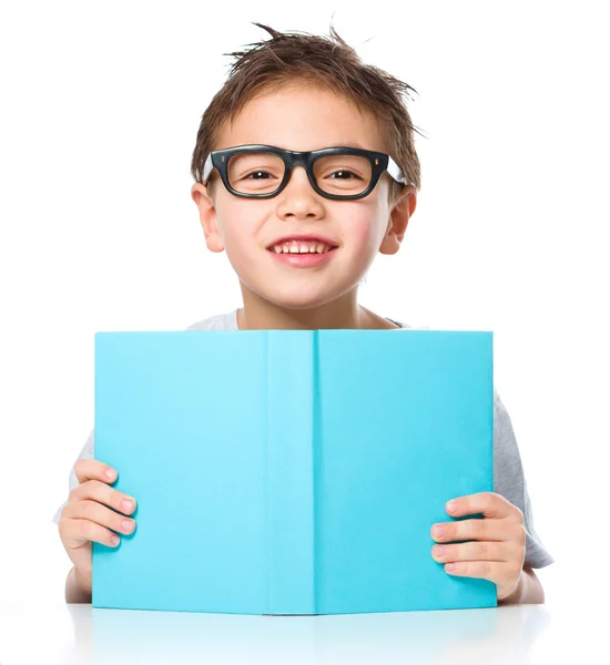 Kleine jongen speelt met boek — Stockfoto