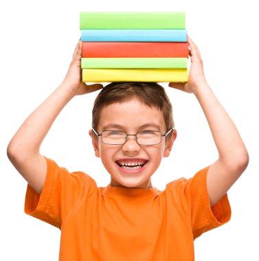 küçük çocuk bir yığın kitap tutuyor