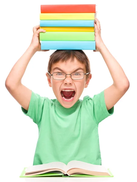 Kleine jongen houdt een stapel boeken — Stockfoto