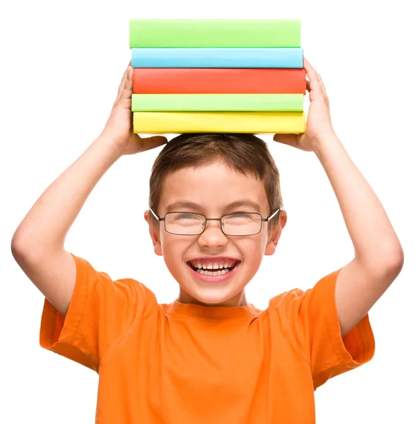 Liten pojke håller en hög med böcker — Stockfoto