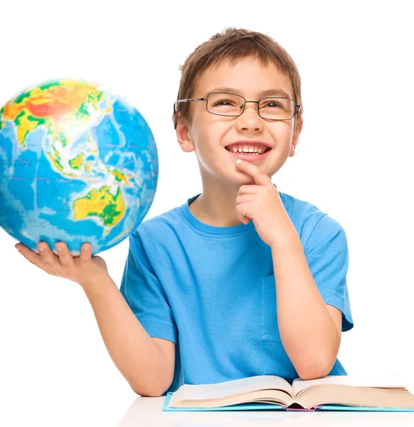 Kleiner Junge hält Globus während er träumt — Stockfoto