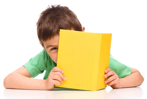 Menino brinca com livro — Fotografia de Stock