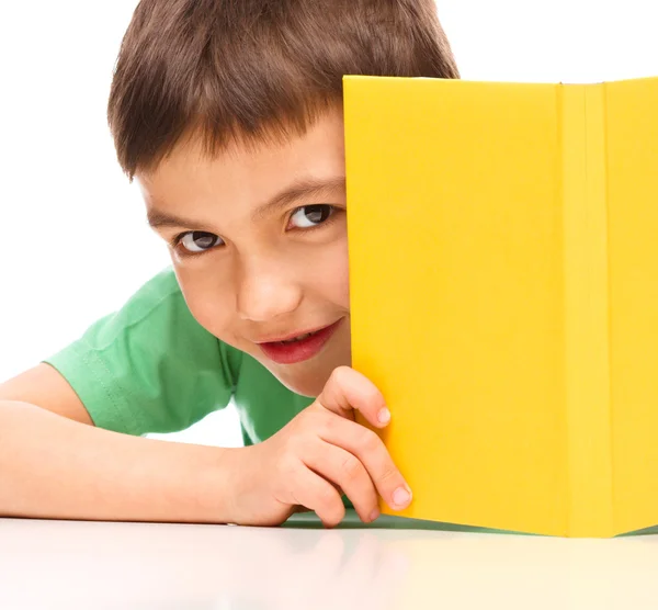 Menino brinca com livro — Fotografia de Stock