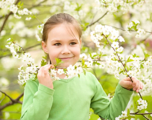 Portrét holčičky poblíž strom v květu — Stock fotografie