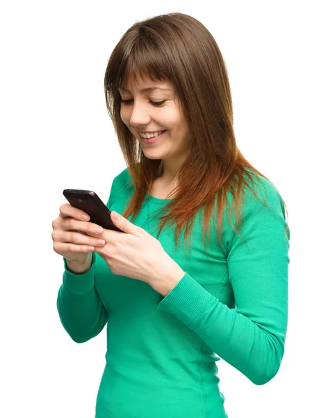 Junge Frau tippt SMS auf ihr Handy — Stockfoto