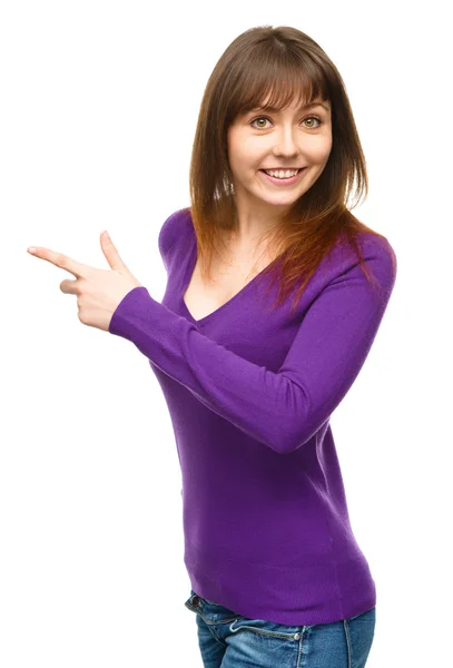 Portrait of a young woman pointing to the left — Stock Photo, Image